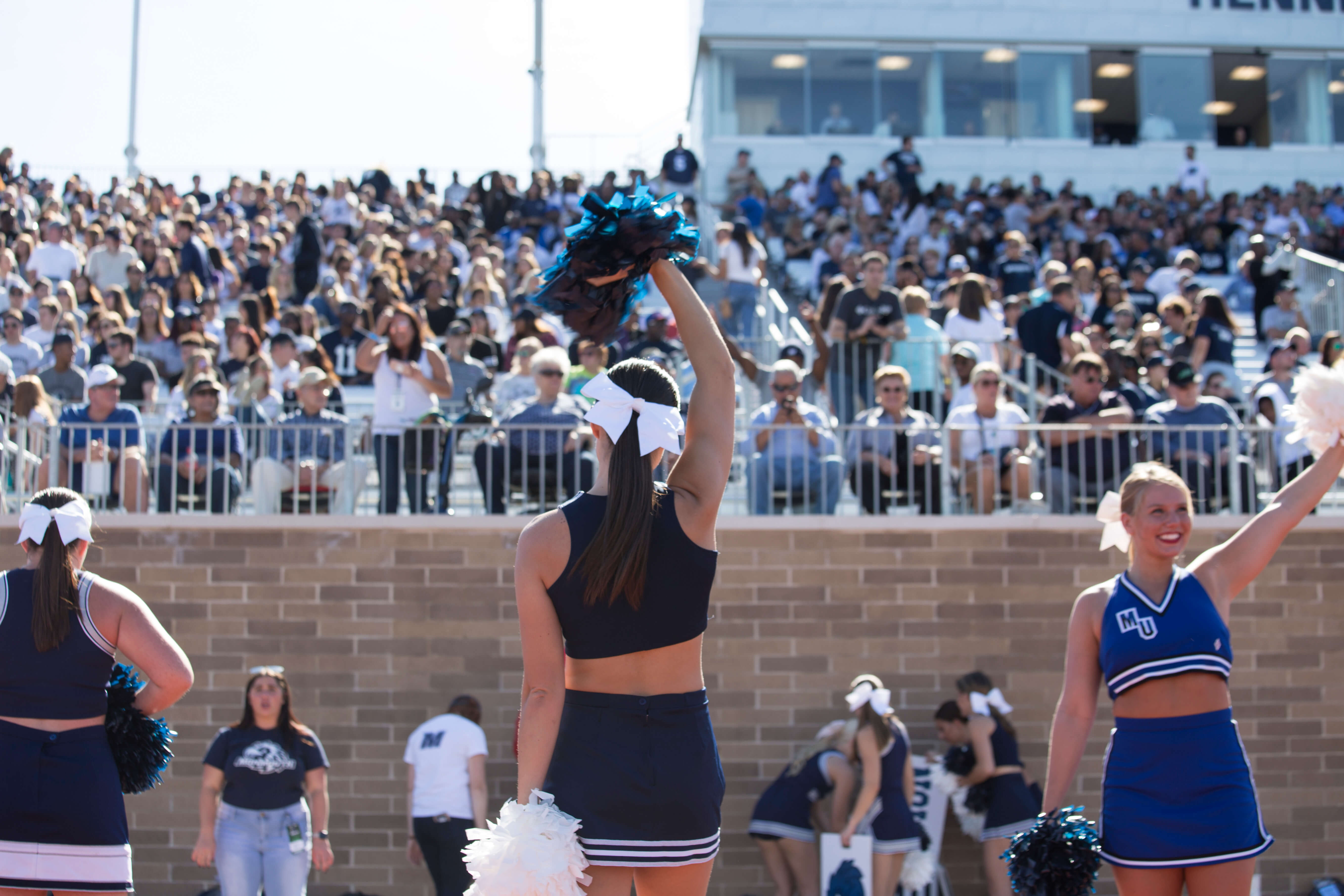Cheerleader in front of the stands at a gane