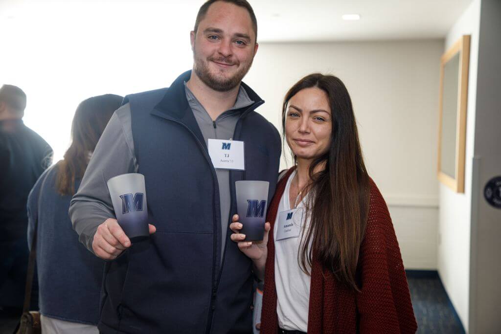 Two Wine vs. Stein participants posing with their Monmouth-branded tumblers