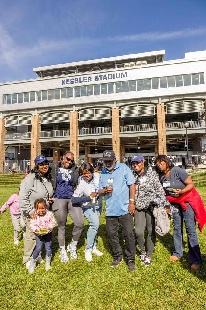 Family members gathered in front of Kessler Stadium smiling at the camera