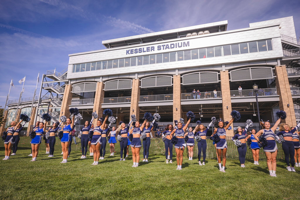 Monmouth Cheer and Dance teams striking poses in front of Kessler Stadium