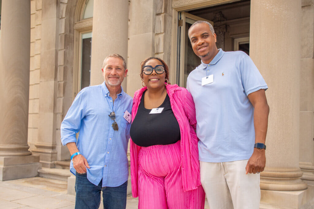 Three Monmouth University alumni gather together to take a photo.