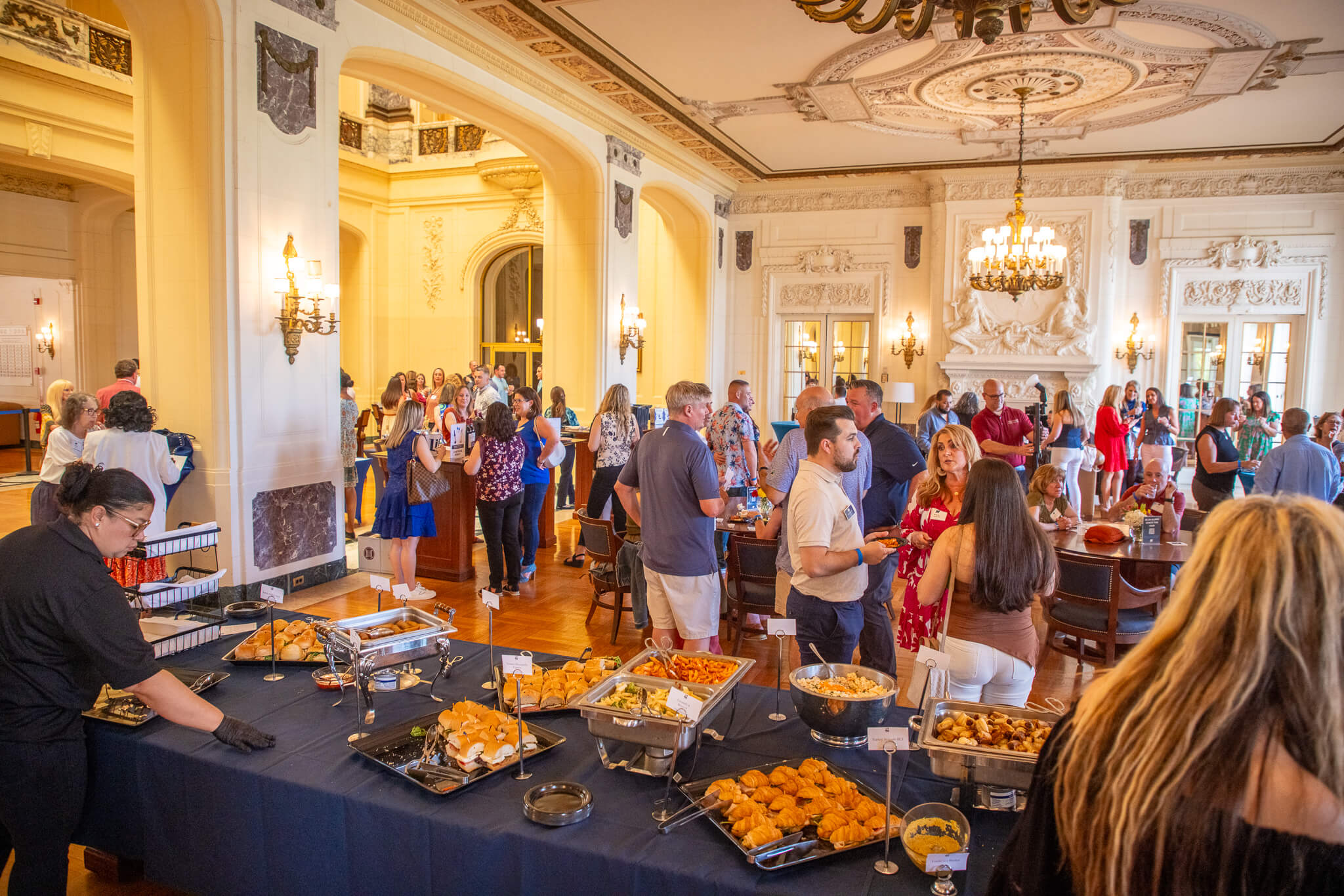 Monmouth University alumni and guests gather inside the elegant Great Hall for the annual Wine & Stein event, enjoying food, drinks, and connections.