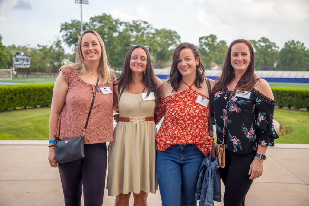 A group of friends reconnecting at the event and getting together to take a photo.