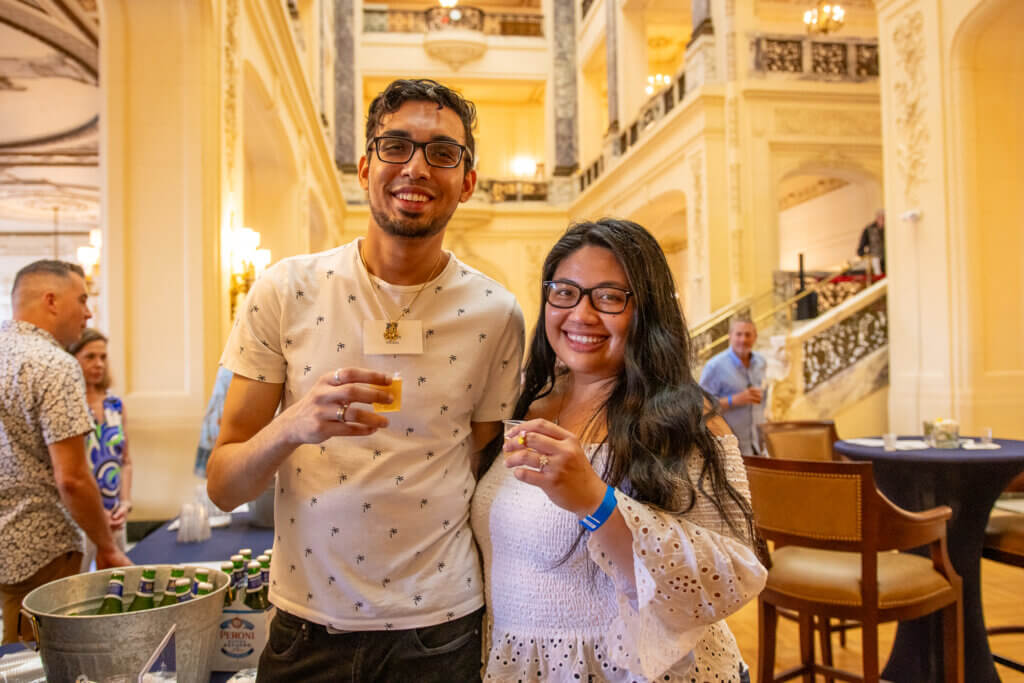 Couple smile and raise their glasses for a cheers to Monmouth University and their annual Wine n Stein event.