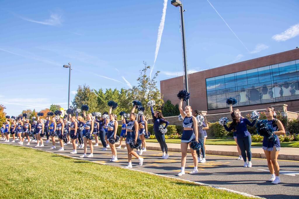 Monmouth cheer and dance teams perfomring in front of the Student center