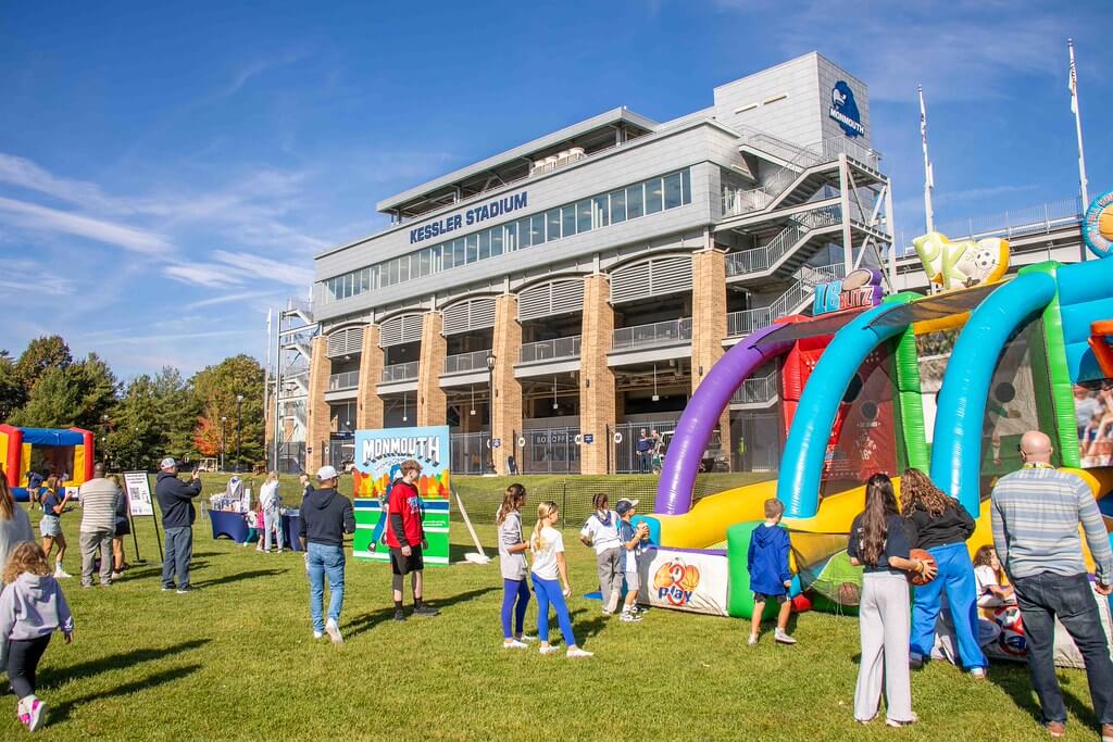 photo of kids playing at the football inflatable with Kessler stadium in the background