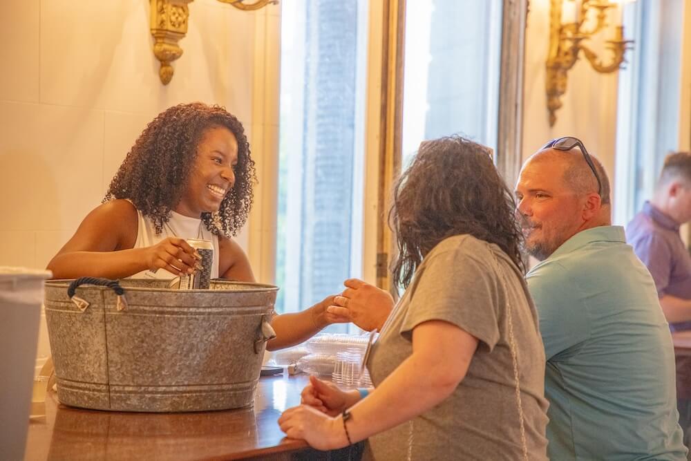 Woman grabbing a beer from an ice bucket for wine and stein patrons