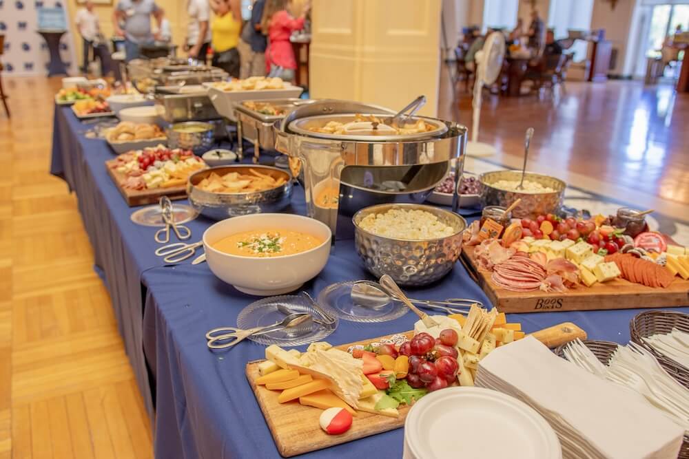 Table filled with different types of food (cheese, fruit, dippers, sauces)