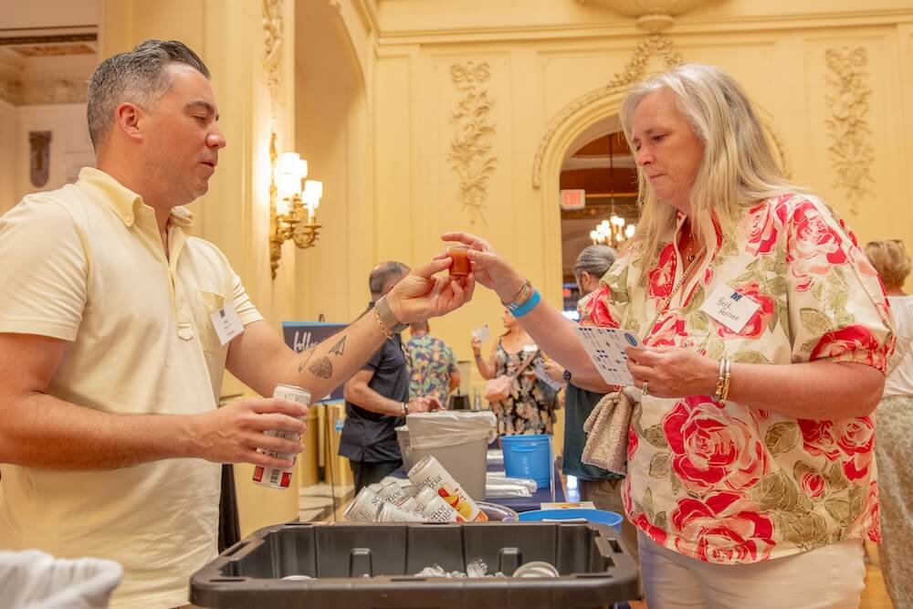 Man and woman exchanging small tasting glass of wine