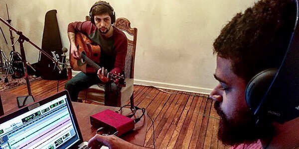 Two musicians recording music.