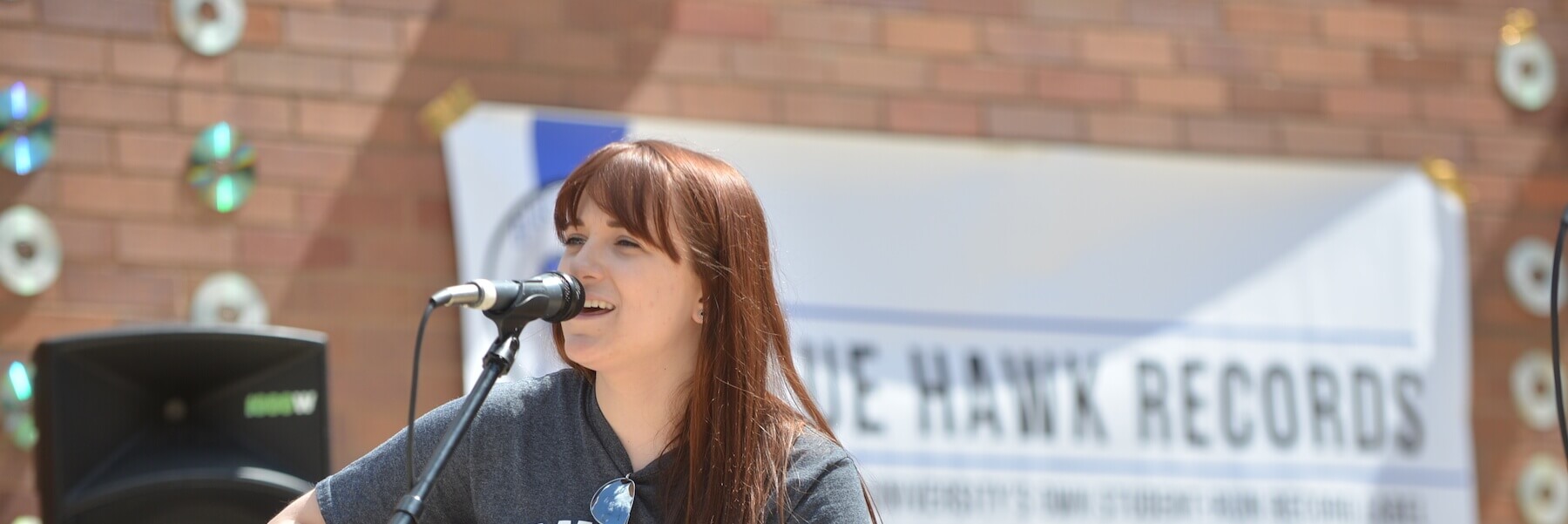 Close-up on a musician singing and playing guitar during a Blue Hawk Records release party.