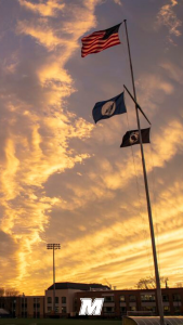 Flags blowing in the wind on a pole from one of the ahtletic fields