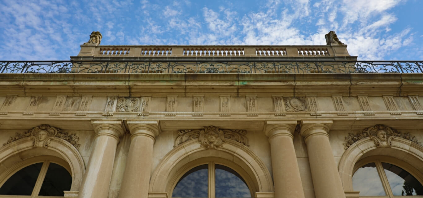 a photo showing off the details of a building with columns and arched windows.