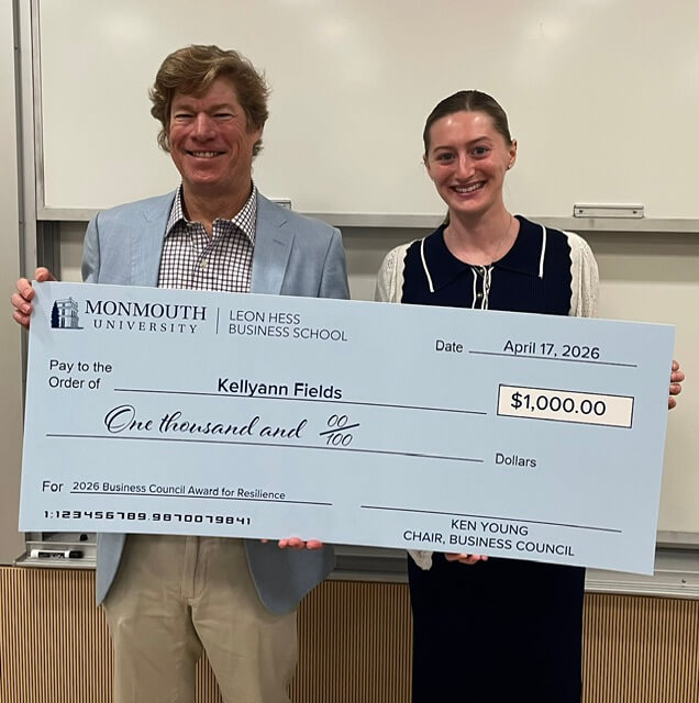 Man and woman holding an oversized check. The check is for $1,000, dated April 17, 2025, and awarded to Kellyann Fields for the 2026 Business Council Award for Resilience. Its from Ken Young, Chair of the Business Council 