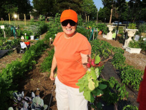 Woman in orange clothing holding radishes