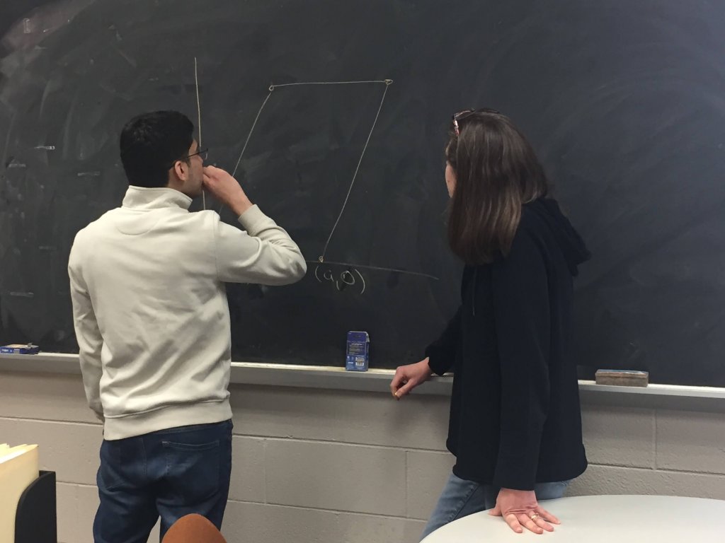 Student Nate Rodriguez and Dr. Susan Marshall tackle a math problem on the blackboard - Photo 1