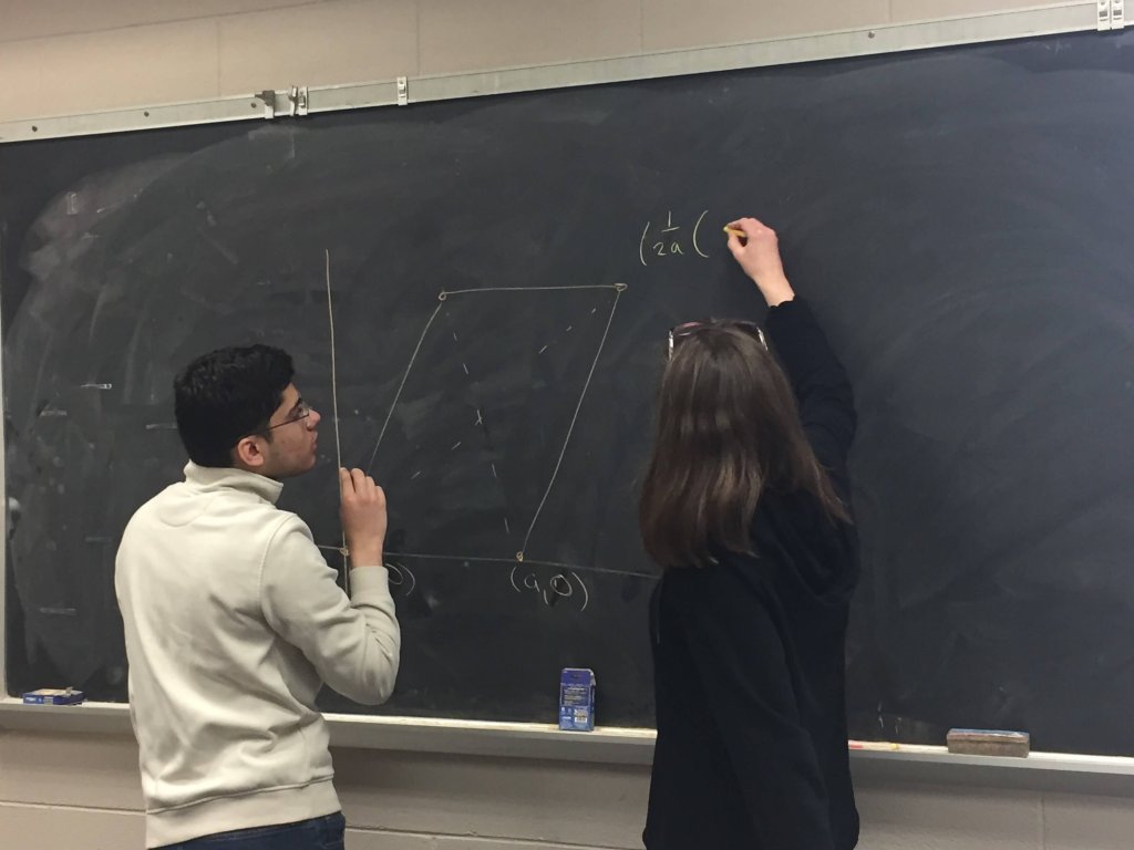 Student Nate Rodriguez and Dr. Susan Marshall tackle a math problem on the blackboard - Photo 3