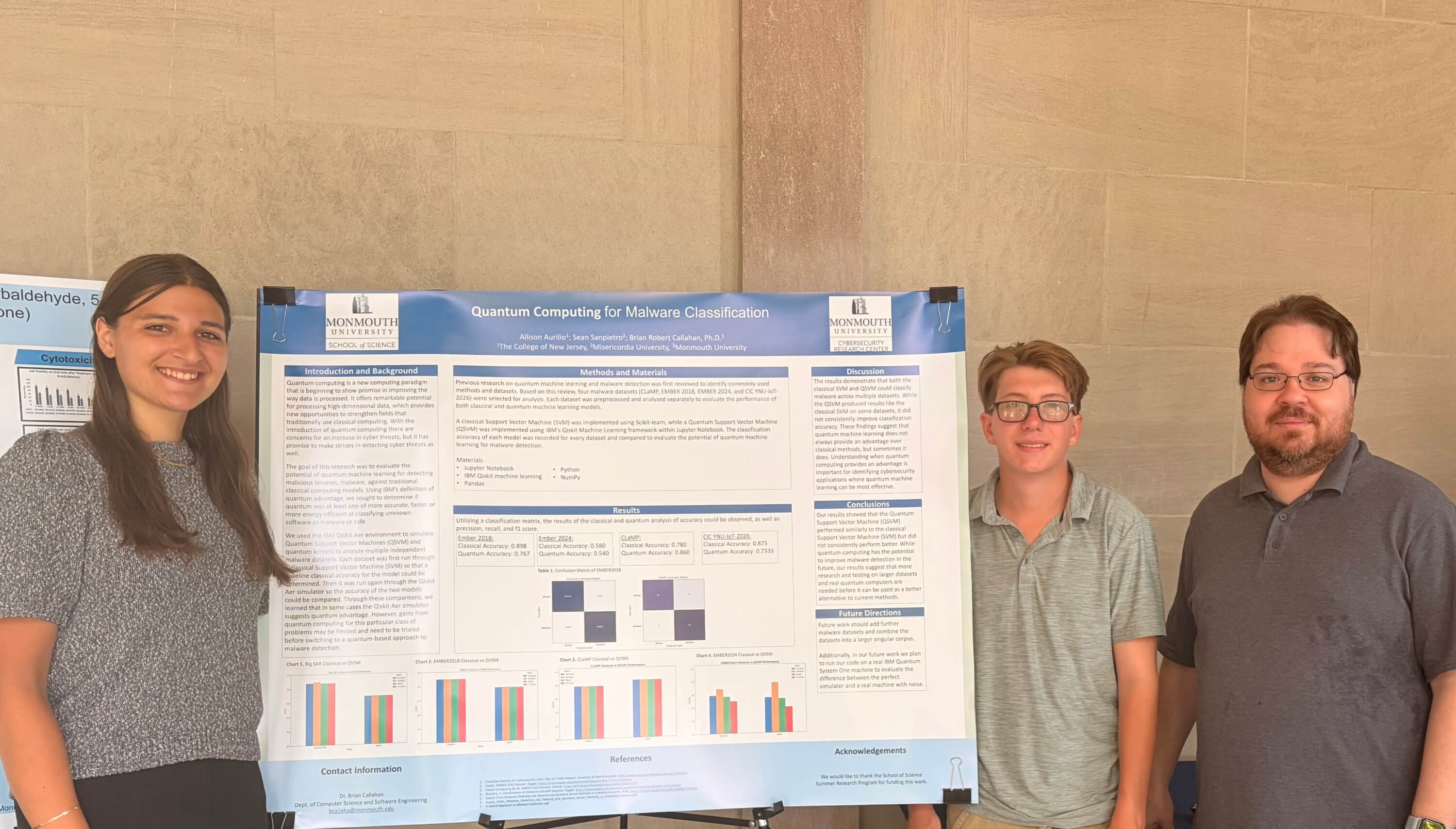 faculty member and students stand beside poster presentation