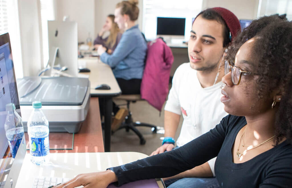 Photo of students working on computers and projects in the classroom