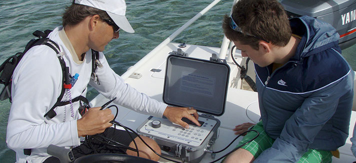 Students using a computer on a boat