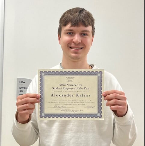 Young man holds up certificate. It reads "2025 Nominee for Student Employee of the Year Alexander Kalina"