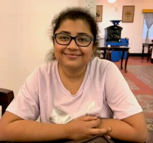 Woman in lavender shirt, smiling