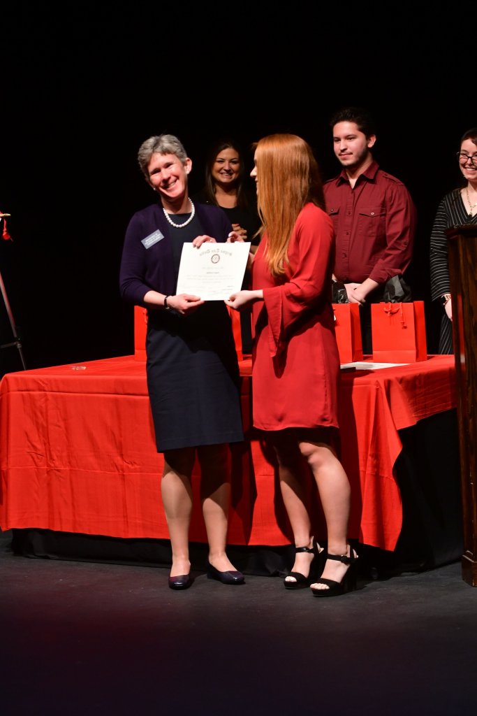 Photo shows Morgan DeWinne presenting Dr. Susan Goulding with her Induction Certificate.