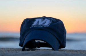 Image of Monmouth hat on beach. Go to the Monmouth University Admission pages.