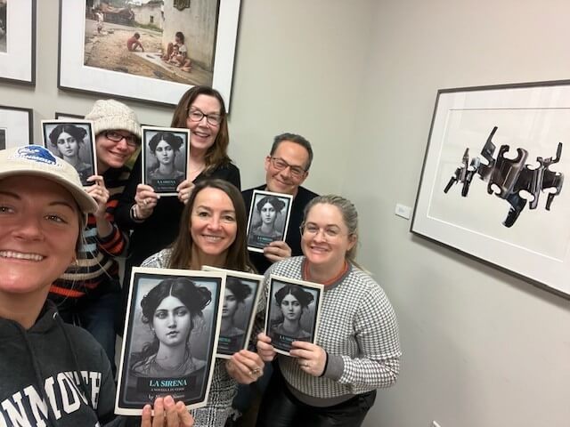 Group of people holding up posters with the illustration of a woman