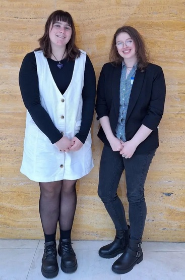 Two women in professional attire posing for a photo