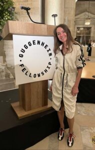 Woman standing near podium that reads "Guggenheim Fellowship"
