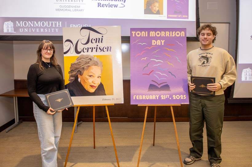 Two students stand near their Toni Morrison posters, holding awards.