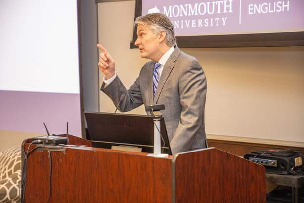 President of University speaks at podium during event.