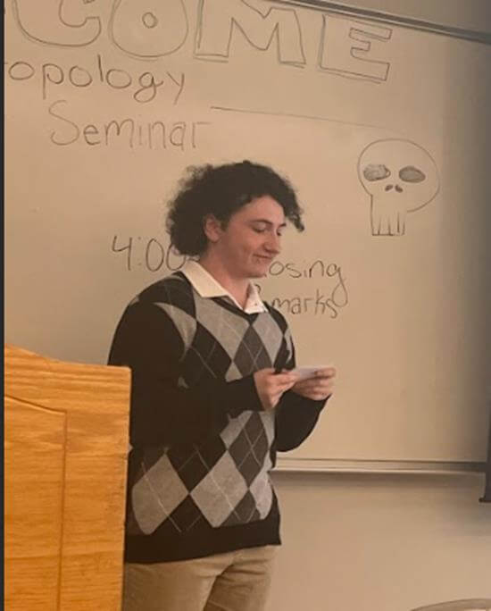 Student delivering presentation while reading from index card