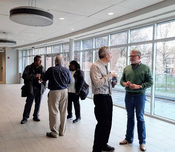 Group of people talking among themselves in a hallway