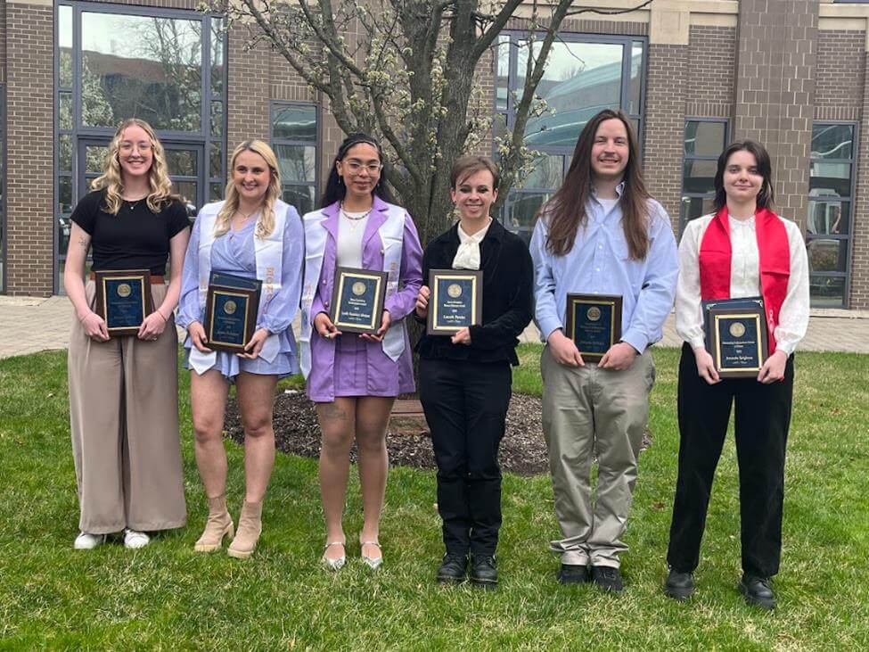 Six young adults holding awards bearing the University seal.