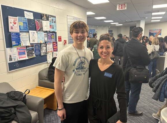 Student and teacher standing in hall during contest event