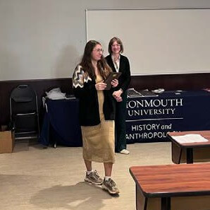 Student walking with award plaque