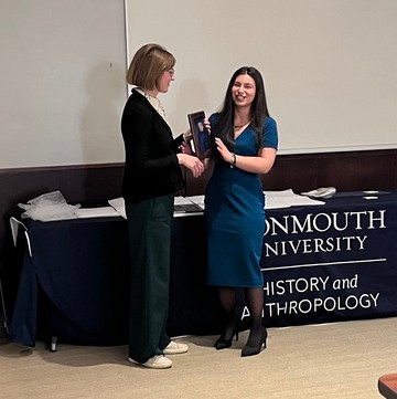 Teacher handing student an award plaque