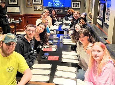 Young men and women sitting at a restaurant table, menus out.