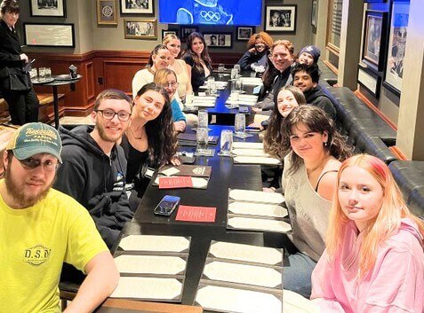 Young men and women sitting at a restaurant table, menus out.