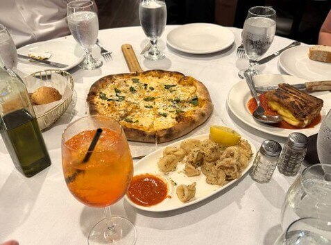 Table with Italian food, including pizza and calamari