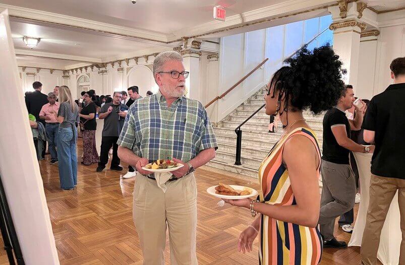 Man and woman in hall speaking with eachother