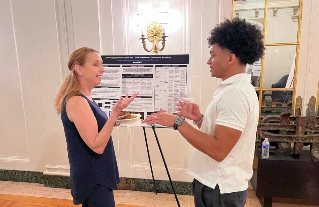 Man and woman near poster presentation, speaking to each other