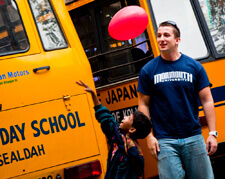 Monmouth student and young boy near school busses during India trip