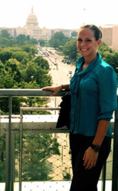 Woman standing on balcony with the capitol building in the background