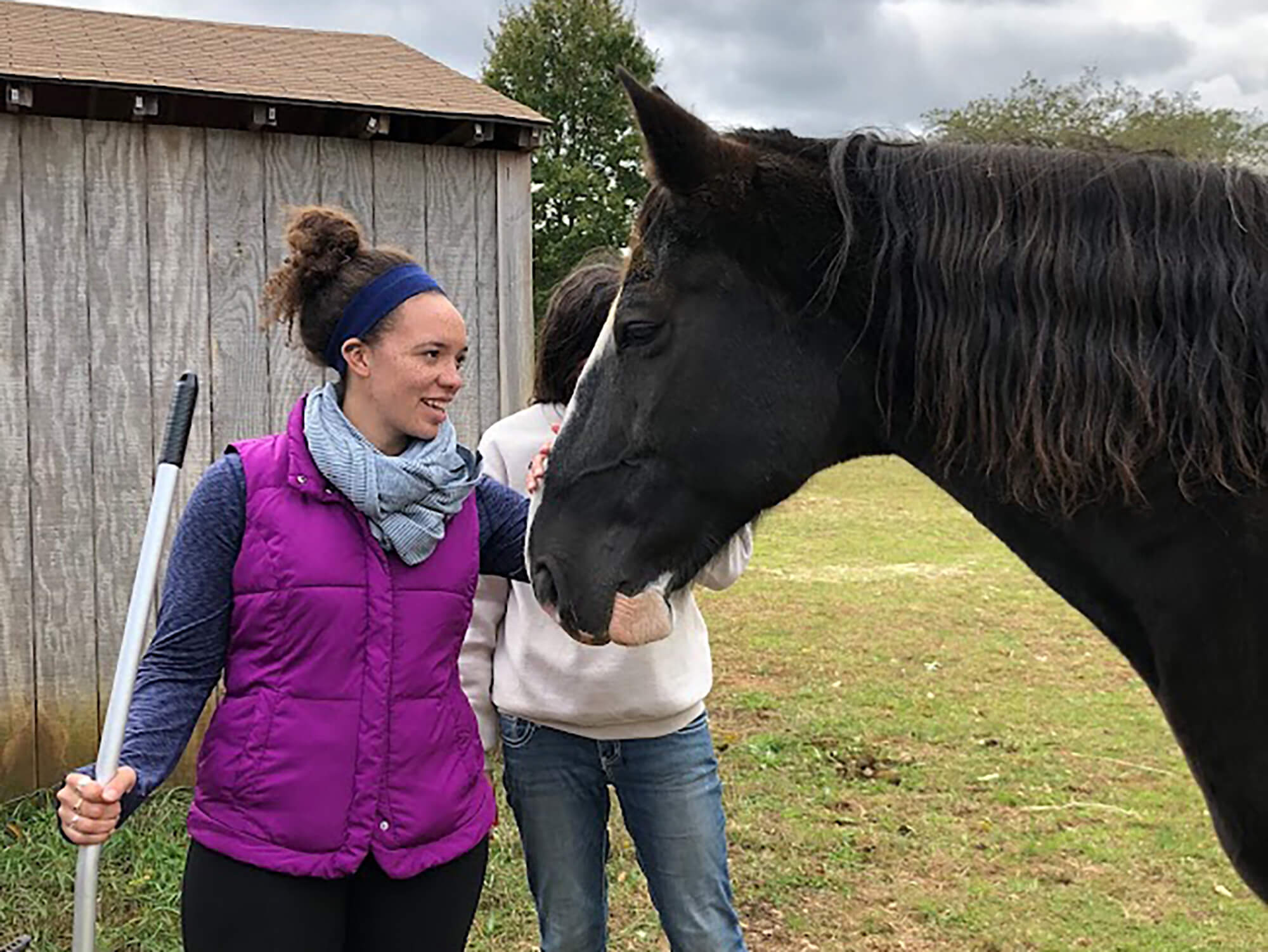 Photo of student petting a horse