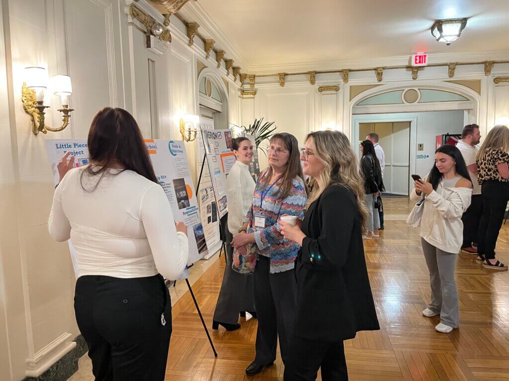 Student presents her poster to 2023 spring student conference attendees.