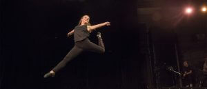 A woman in mid leap duing a dance.