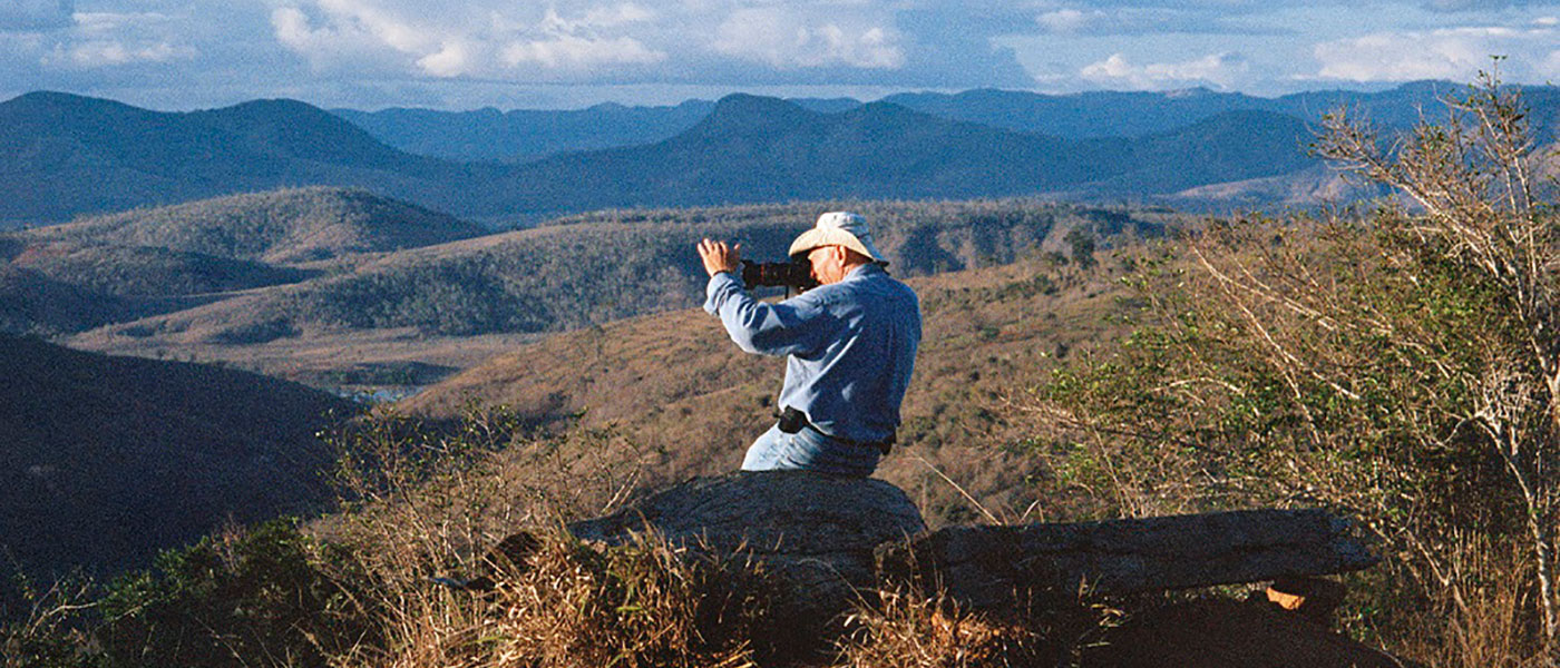 Photo of photographer with camera sitting in mountainous setting from the film Salt of the Earth